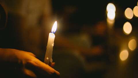 Hände halten eine Kerze