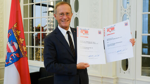 Chef der Staatskanzlei mit Urkunden zur Auszeichnung "Starkes Dorf"