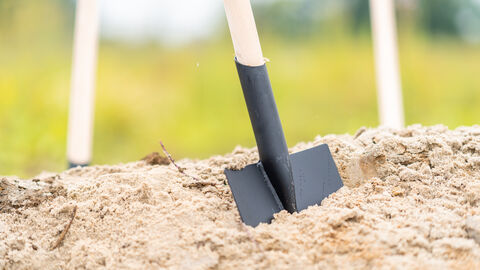 Schaufel steckt in einem Sandhaufen