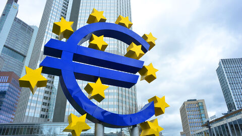 Blaues Eurozeichen steht vor einem Hochhaus.