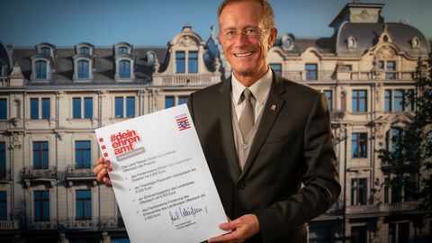 Staatsminister Axel Wintermeyer mit einer Förderurkunde