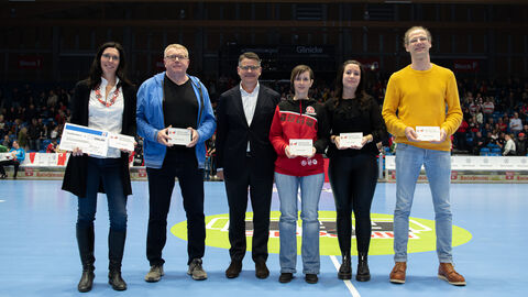 Es stehen auf einem Spielfeld der MT Melsungen: Carolin Goujard, Uwe Lohmann, Ministerpräsident Boris Rhein, Jessica Fetzner Anja Scholtz und Stefan Döring. Die Ausgezeichnete Ellen Fehr fehlt auf dem Bild.