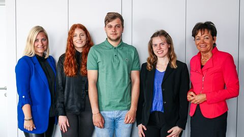 Europaministerin Puttrich mit drei Frauen und einem Mann vor einer weißen Wand, alle lächeln in die Kamera.